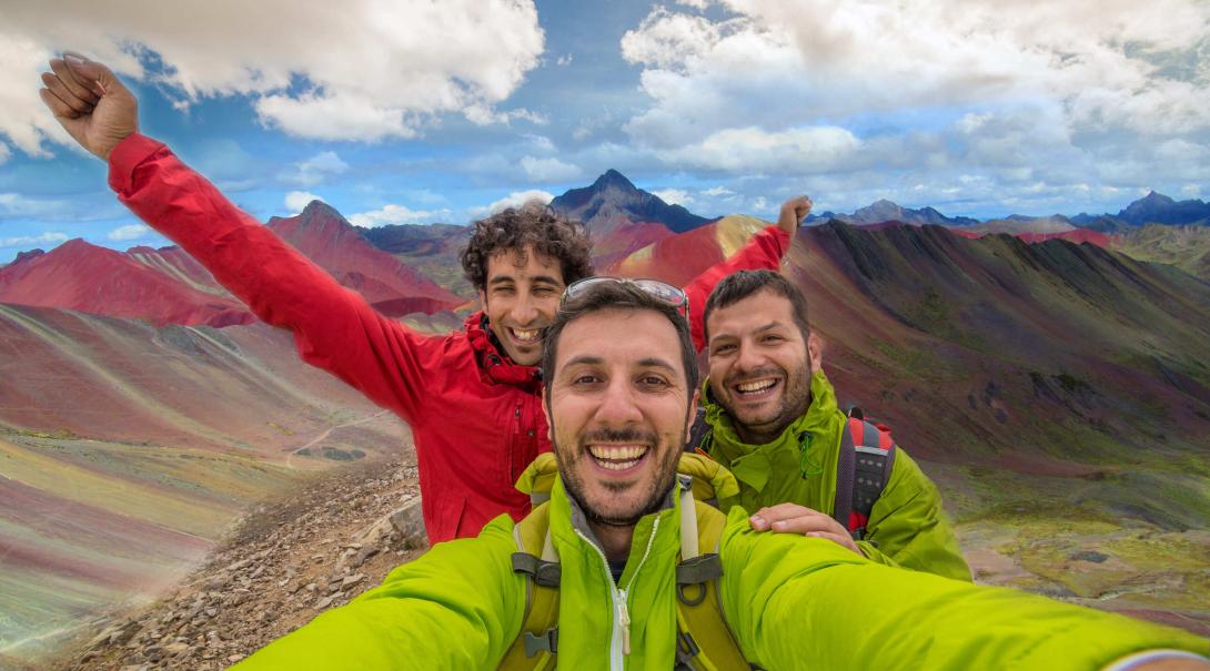 Projects Abroad volunteers discover how travel changed them in 2020. Travellers take a selfie with the Rainbow Mountains of Peru in the background.
